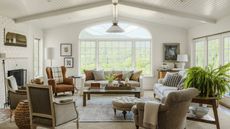 living room with white walls cream sofas and arched window