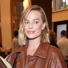 Margot Robbie wears a chestnut leather jacket