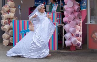 Jean Slater runs in a wedding dress at a theme park.