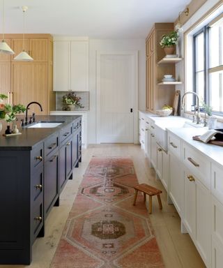 Shaker kitchen with white cabinets along the walls and a dark blue kitchen island.