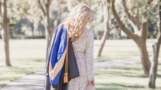 Woman graduating with gown thrown over shoulder