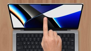 MacBook with a finger pointing at the screen