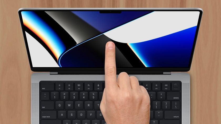 MacBook with a finger pointing at the screen