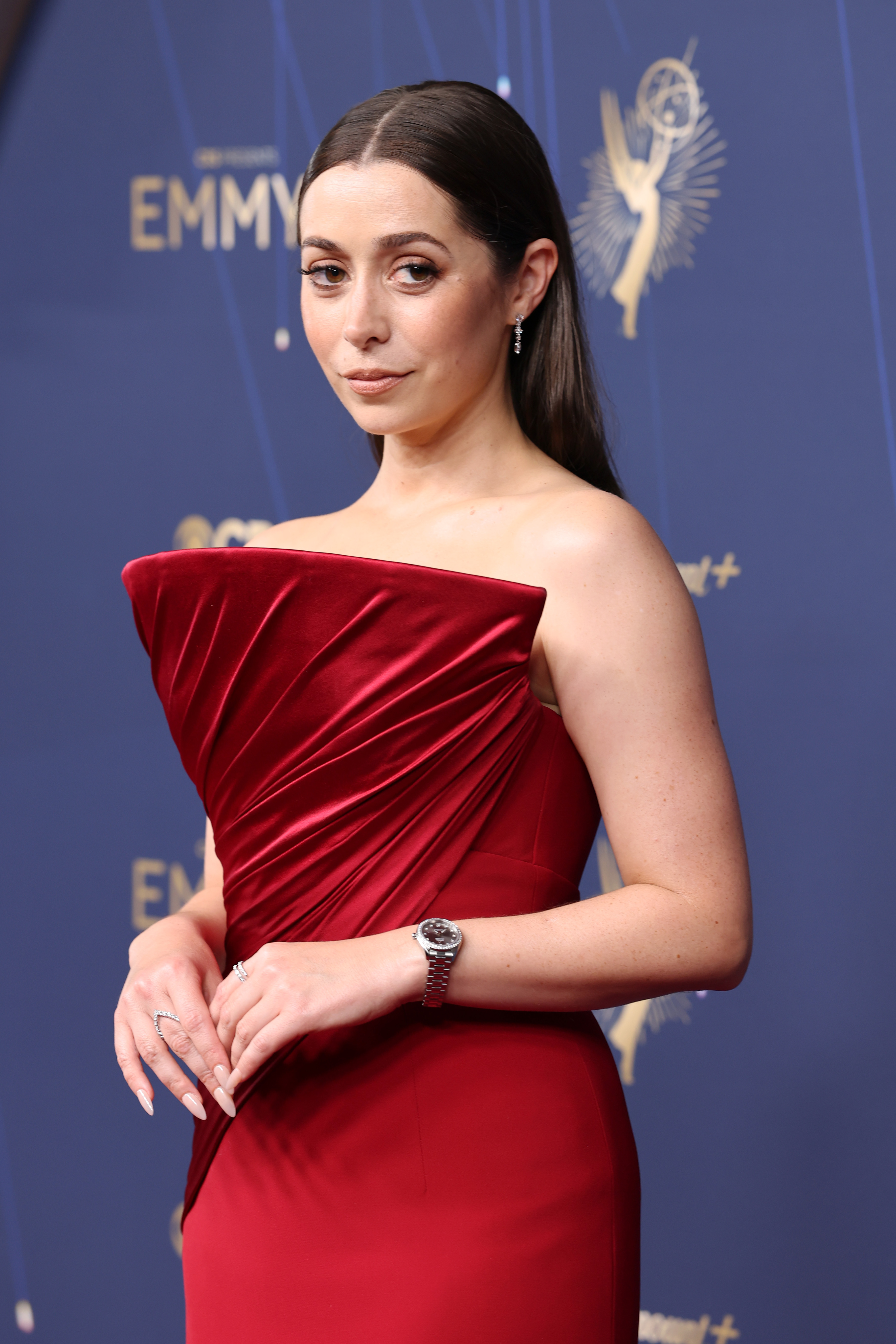 Cristin Milioti in a red gown with a silver watch