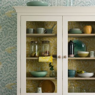 white cabinet with patterned wallpaper interior
