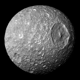 Saturn’s moon Mimas, as imaged by the Cassini spacecraft, is barely large enough for gravity to pull it into a spherical shape. The vast crater Herschel, which makes Mimas look like the Death Star, is the scar of an impact so large it almost destroyed Mimas!