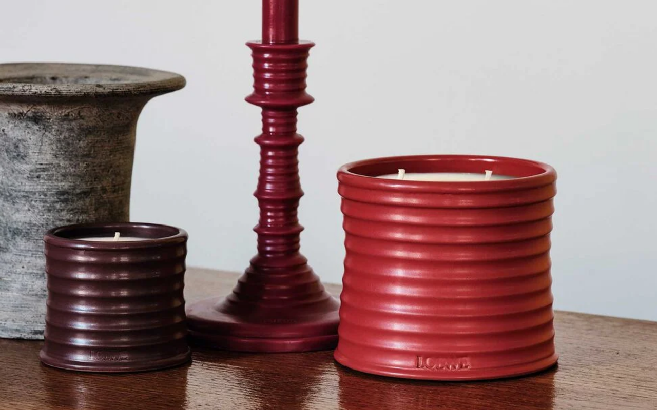 Two red ribbed candle jars and a tall red candle stick