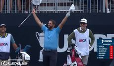 Matthieu Pavon raises his arms in the air next to his caddie following his ace
