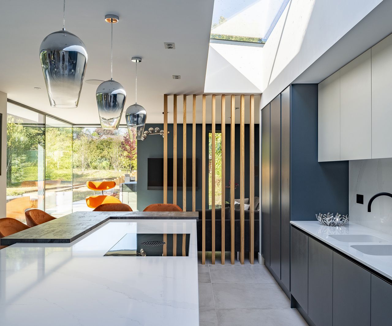 A kitchen in a broken plan kitchen and living room area cordoned off with a wooden rail