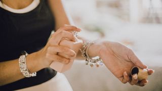 A woman sprays perfume on her wrist