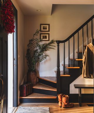 neutral hallway with black staircase and black bench