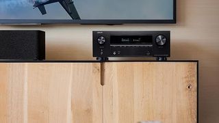 A Denon AVR on a modern wooden media unit