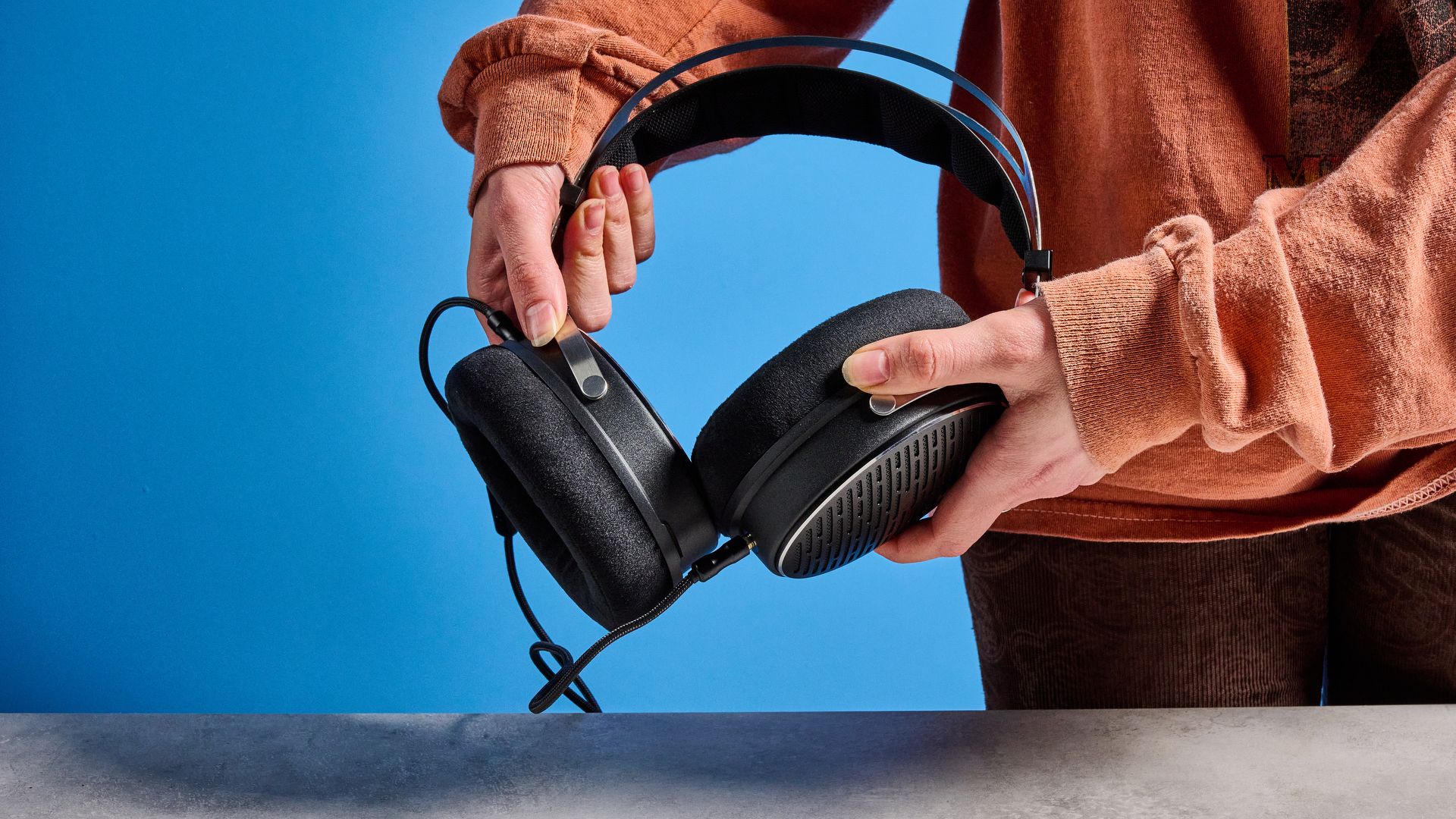 the FiiO JT3 headphones in black and silver shown against a blue tom's guide background