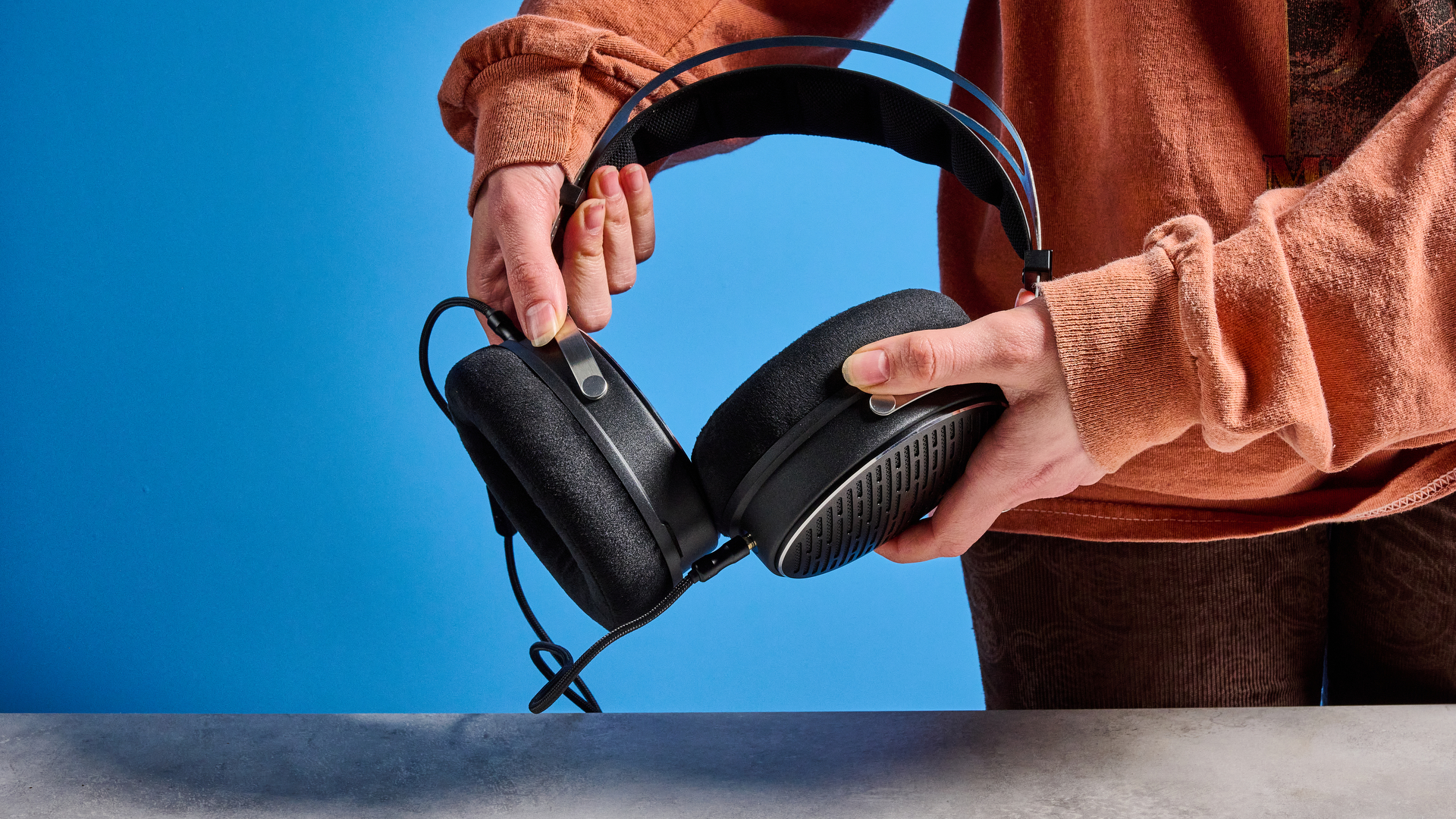 the FiiO JT3 headphones in black and silver shown against a blue tom's guide background