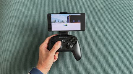 The SteelSeries Stratus+ mobile and PC controller on top of a green carpet surface