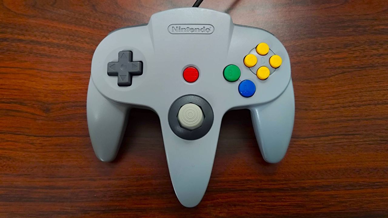 N64 controller after restoration on woodgrain desk.