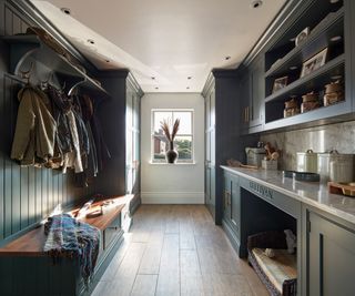 utility room with sink, cupboards, built in dog bed, bench and coat hooks