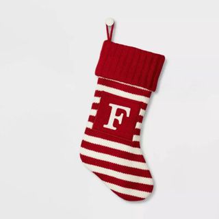 Knit Striped Monogram Christmas Stocking against a gray background.