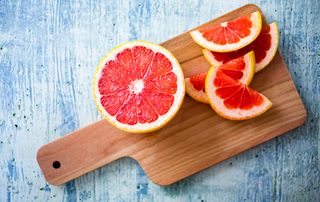 Low calorie fruits, grapefruit, sliced on a wooden board