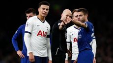 English referee Anthony Taylor (C) points out to players where comments and objects are coming from in the crowd during the English Premier League football match between Tottenham Hotspur and