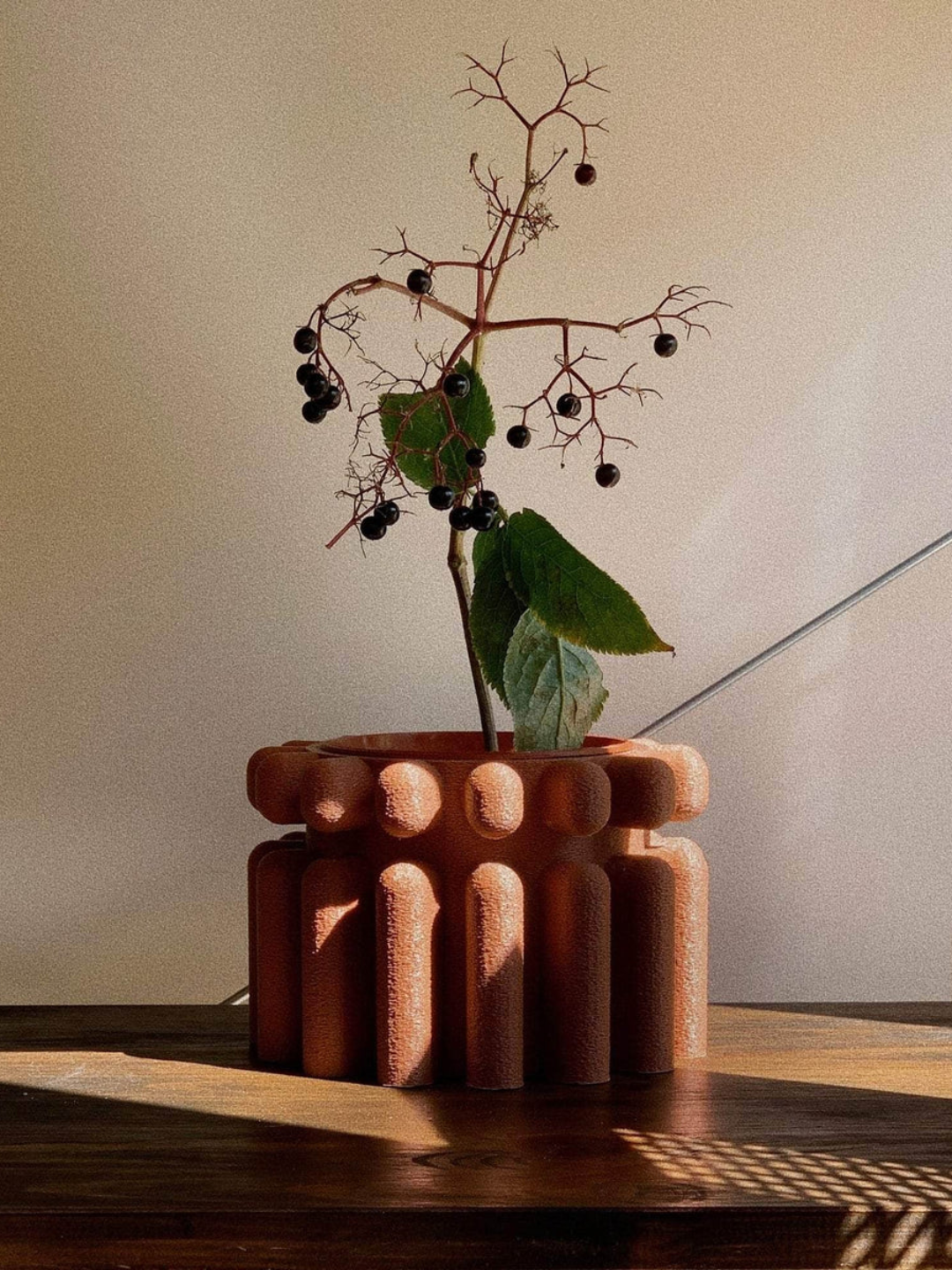 A textured terracotta-colored planter from Amanita-Labs