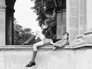 Black and white photograph of a man in a shorts suit lounging