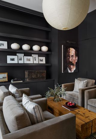Cozy living room with black walls and velvet armchairs