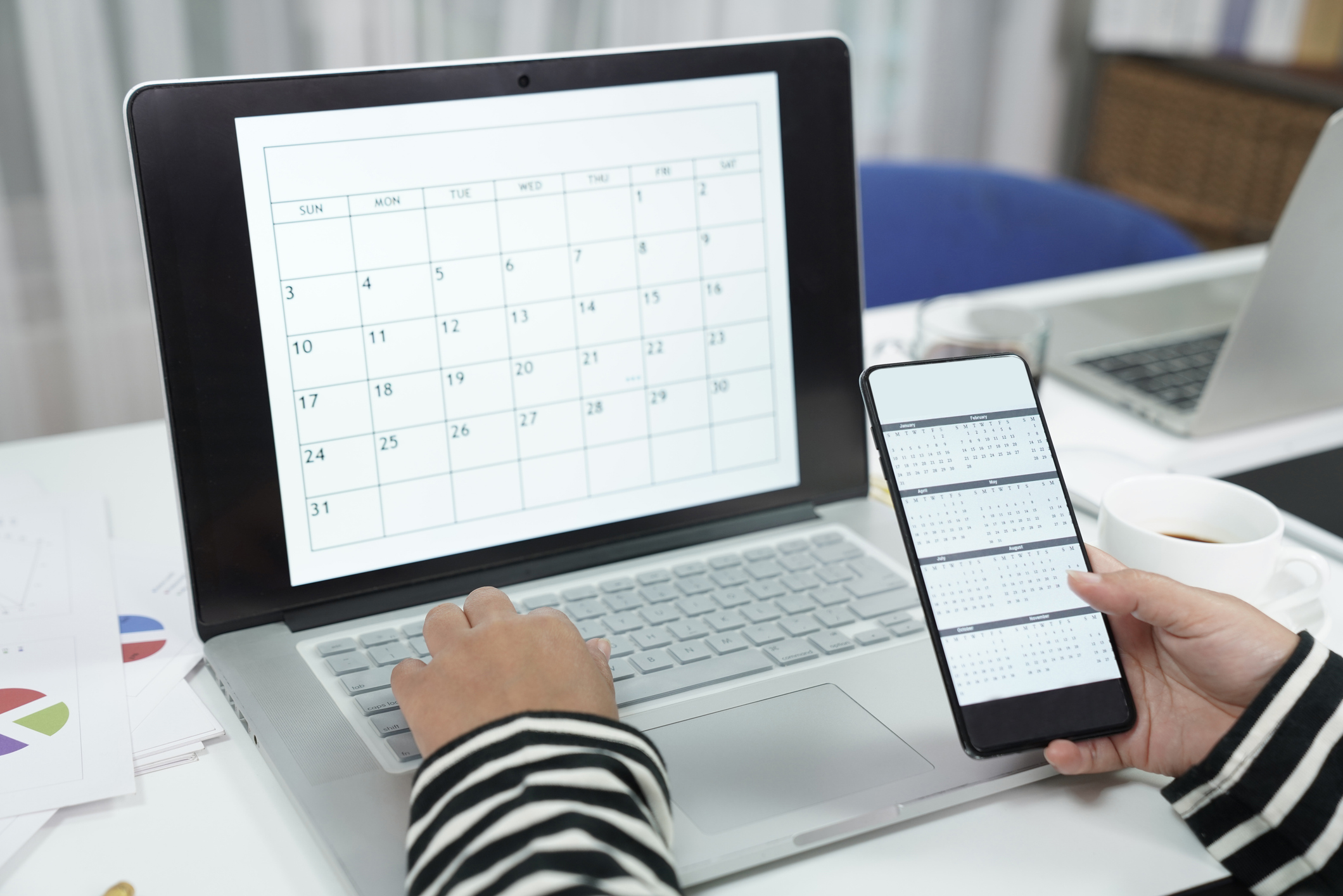 Hand of woman using phone to checking calendar while working on desk office