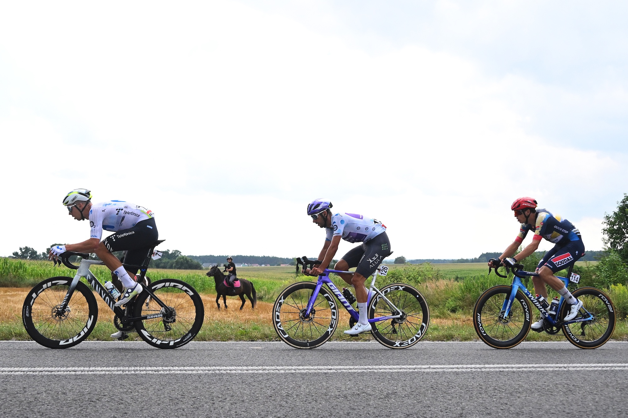 Filip Maciejuk of Movistar, Dries De Bondt of Jayco AlUla (in the Polka Dot Mountain Jersey) and Paul Magnier of Soudal-QuickStep compete in the breakaway