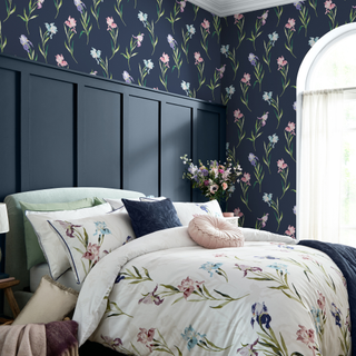 a floral bedroom with floral wallpaper and matching bedding