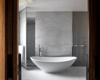 bathroom with marble walls and white slipper bath