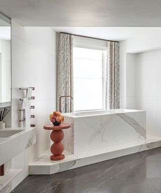 Modern bathroom with tub on a marble plinth