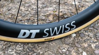 A DT Swiss carbon rim on a concrete floor 
