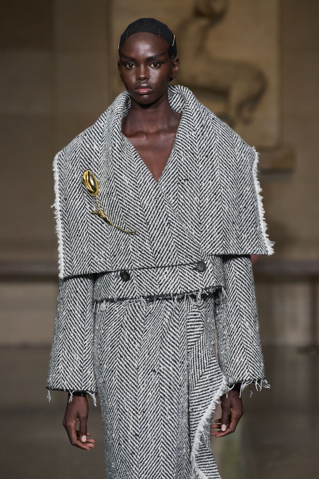 models wearing brooches on the runway