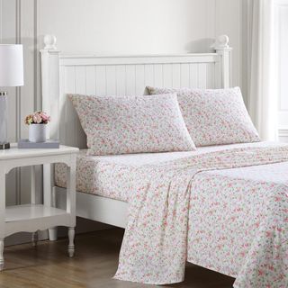 Laura Ashley Cotton Percale Bedding Set on a bed beside a nightstand.