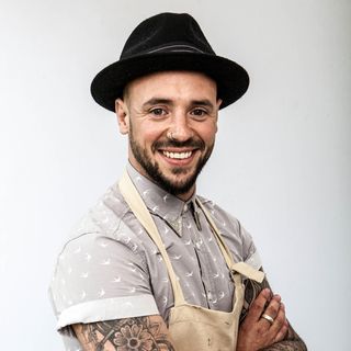 bake off contestant with black hat and apron