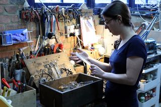 Jolene Farmer in her workshop restoring a gas chandelier.