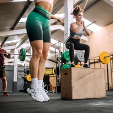 Two women trying circuit training in a Crossfit box