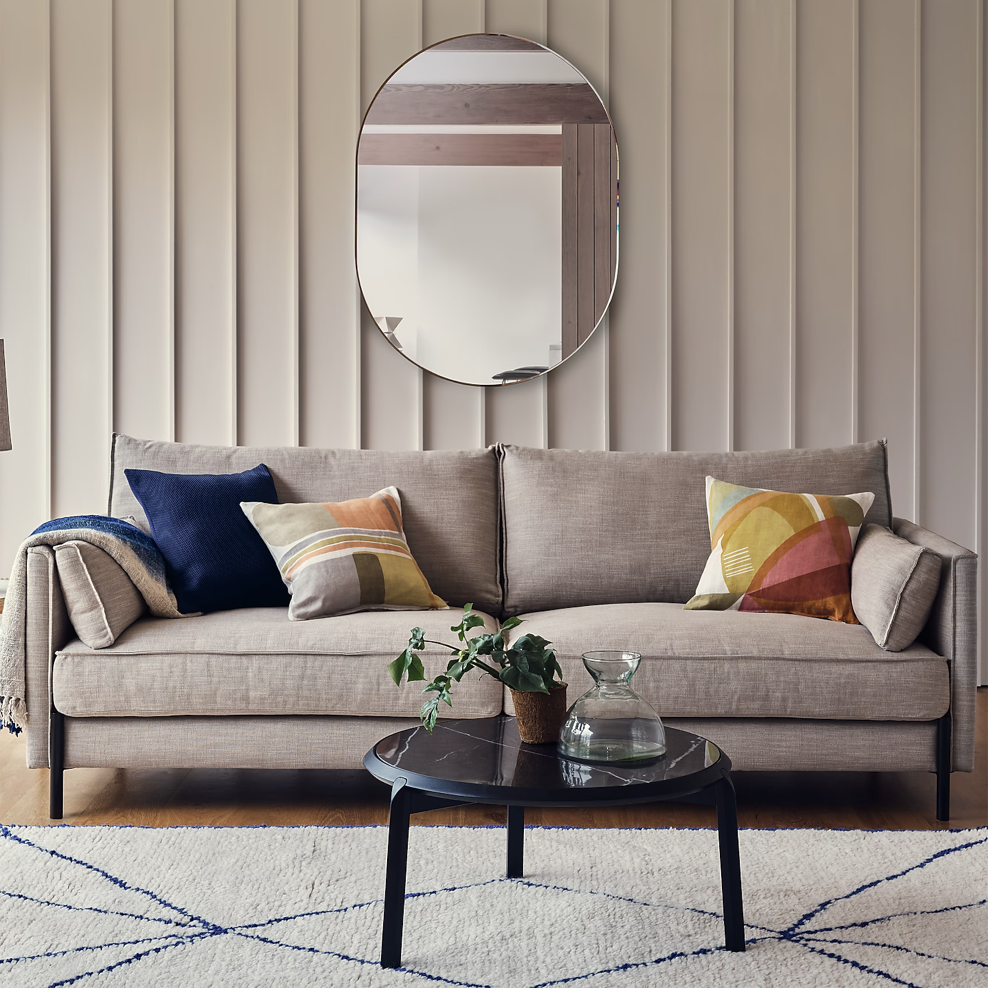 Grey Tortona sofa by Heal&#039;s in front of a ridged wall with a large mirror above it
