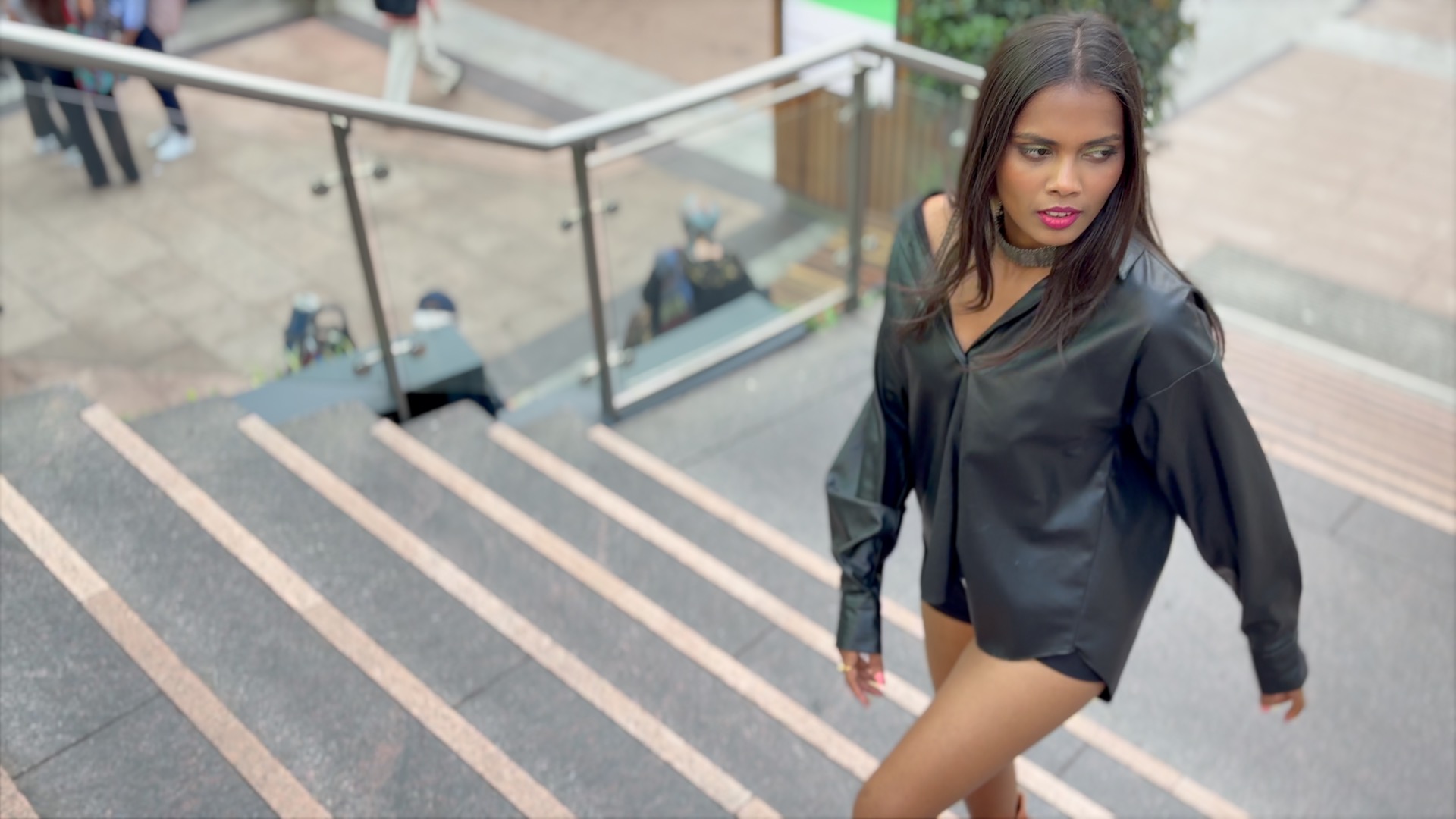 Screenshot from a video clip showing a model walking up stairs