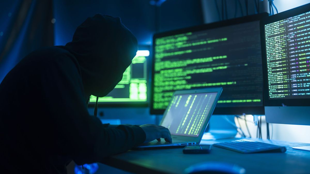 A stock image of a hacker using a computer to infect a server with a virus