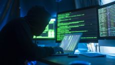 A stock image of a hacker using a computer to infect a server with a virus
