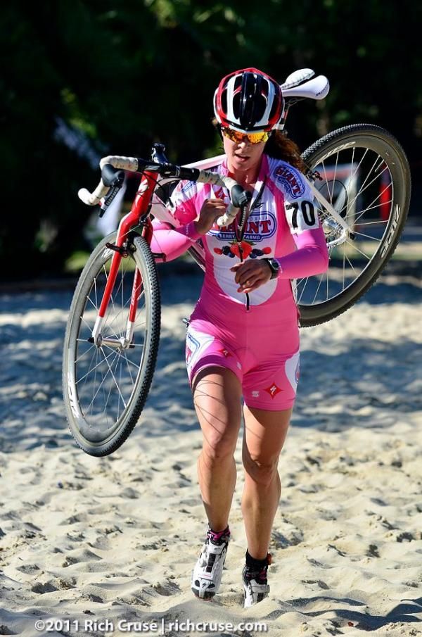 Teal Stetson-Lee (California Giant-Specialized) shoulders her bike through the sand section.