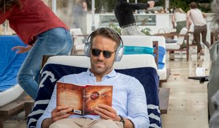 Ryan Reynolds tries to read The Secret in peace in The Hitman's Wife's Bodyguard.