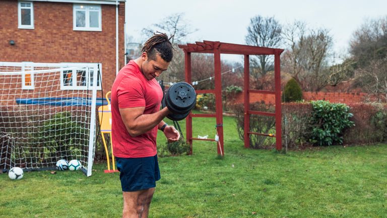 Man using dumbbells on sale at home