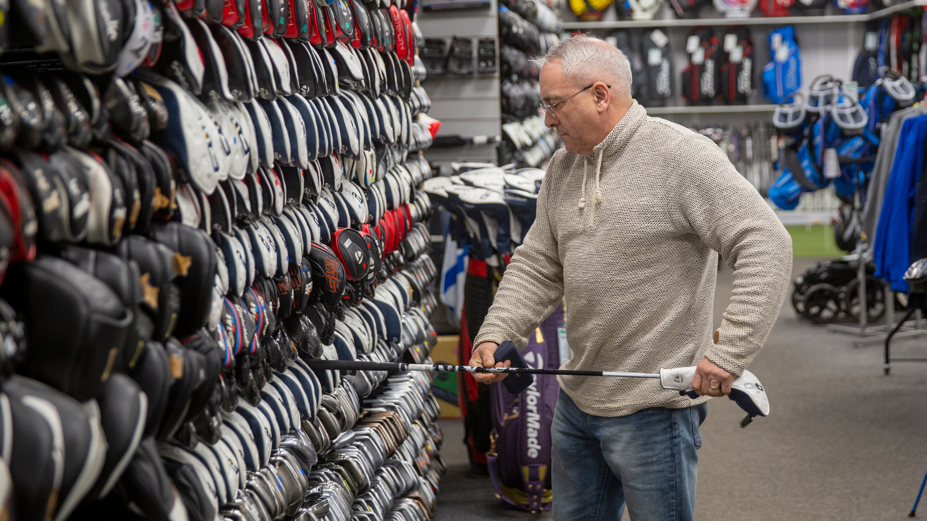 golfer looking at a club at golfclubs4cash store