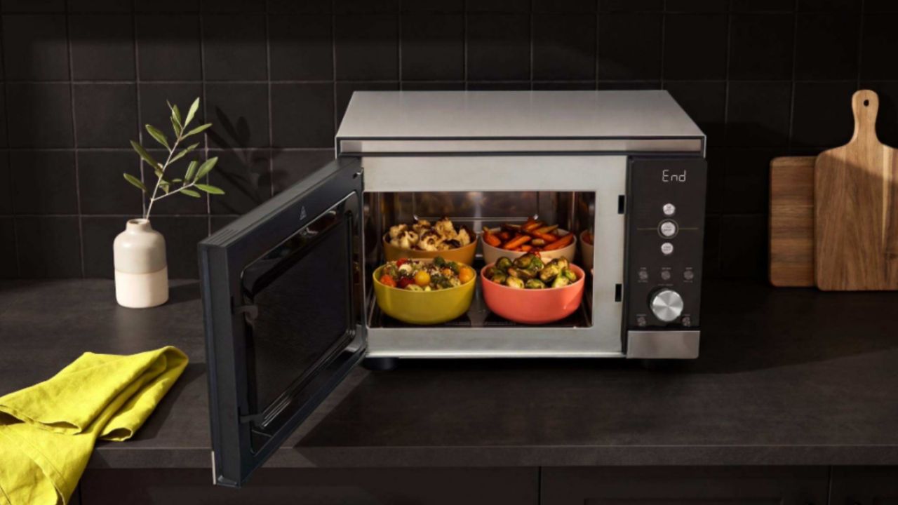 Ninja Crispi Microwave on a counter cooking various foods