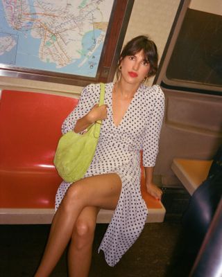 Jeanne Damas di kereta bawah tanah NYC dengan pakaian retro.