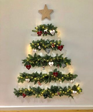 Wall mounted Christmas tree with fairy lights and red and white decorations