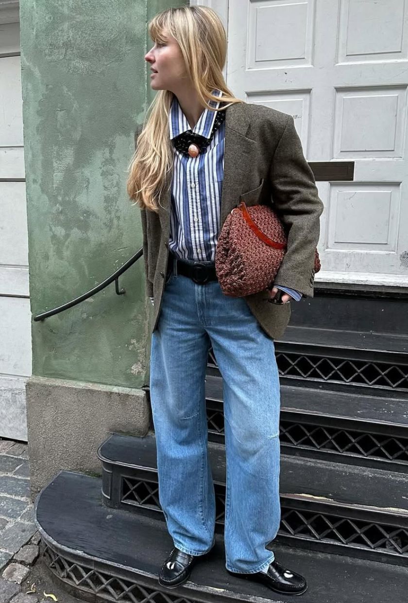 @annejohannsen wears a blazer, striped shirt, light-wash jeans, loafers and a leather clutch bag